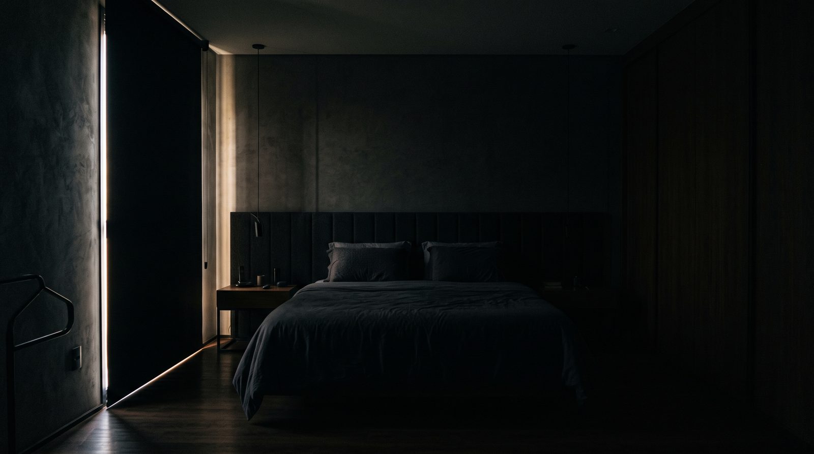 Quarto com persiana blackout fechada e o ambiente no escuro