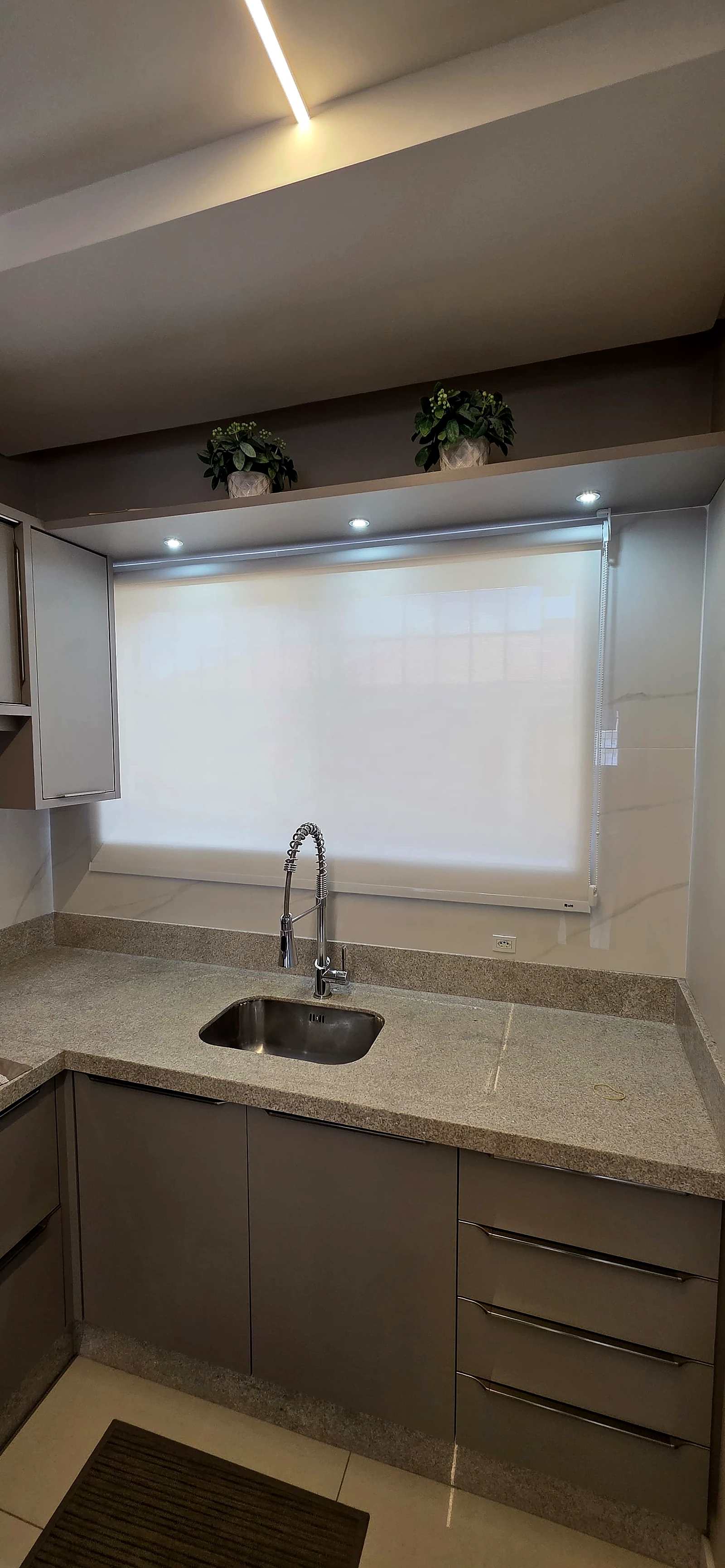 Cozinha com persiana de Tela Solar 1% fechada, com o ambiente ainda claro