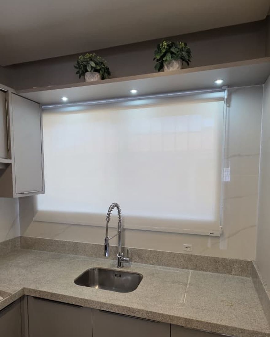 Persiana rolô tela solar 1% branca instalada em cozinha