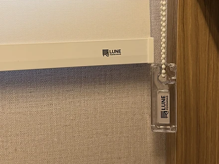 Detalhe da barra inferior com a marca Lune e do pingente de acrílico do acionamento por corrente