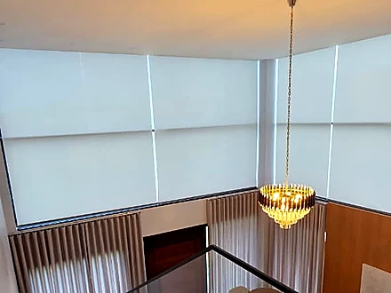 Sala de pé-direito alto com persianas Tela Solar 1% motorizadas instaladas