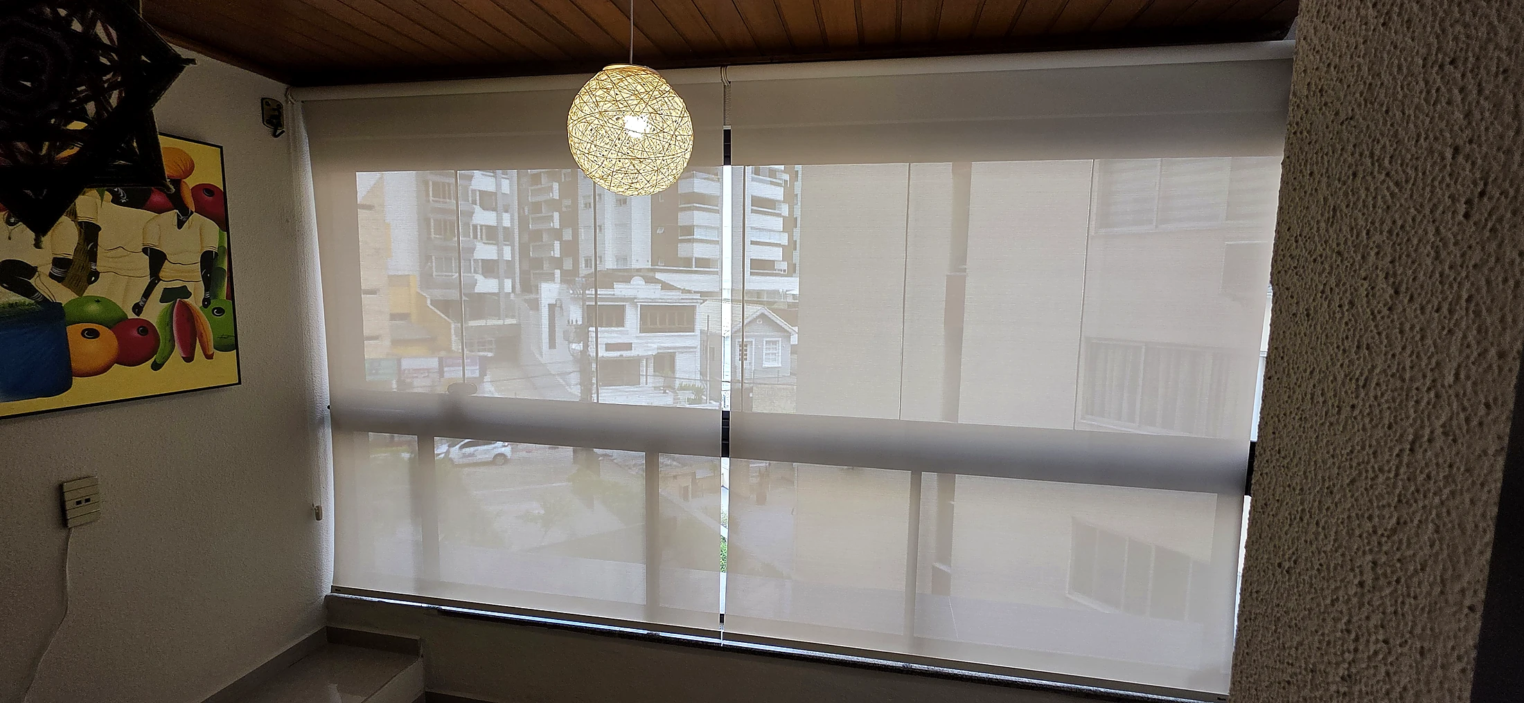 Varanda com persiana de Tela Solar 3% fechada e a vista aparecendo pelo tecido