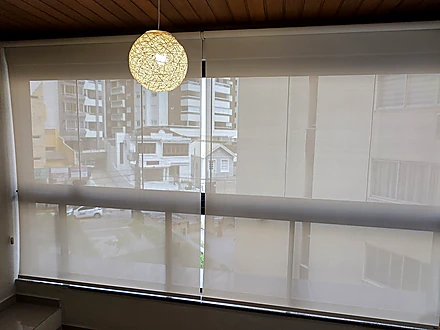Persiana Tela Solar 3% bege instalada diante de uma vista para o exterior
